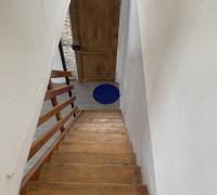 Vista desde el segundo nivel del departamento dúplex, donde se distribuyen tres dormitorios. La imagen muestra la escalera de madera sólida, que conecta ambos pisos y aporta calidez al interior..”