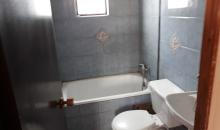 Un baño ubicado en segundo piso, tina, wc y lavamanos.