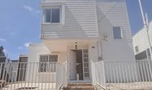 Frente, se aprecia reja de antejardín con dos entradas laterales al patio