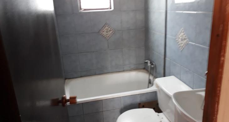Un baño ubicado en segundo piso, tina, wc y lavamanos.
