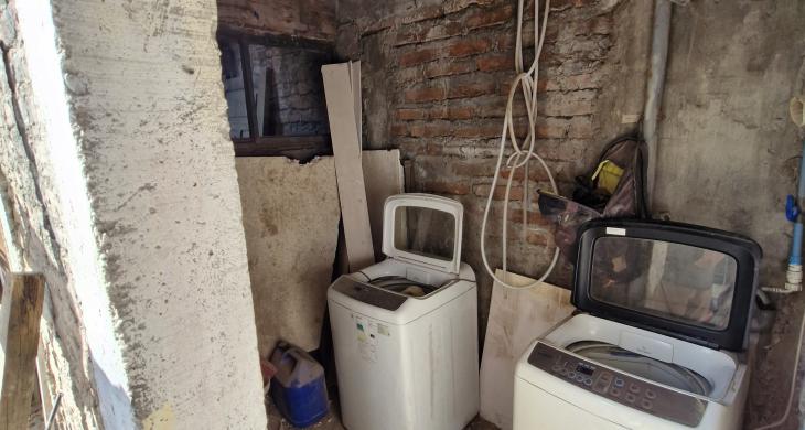 Logia cerrada de material solido con radier a un costado del patio