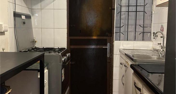 Cocina con vista hacia puerta de salida, acceso a logia